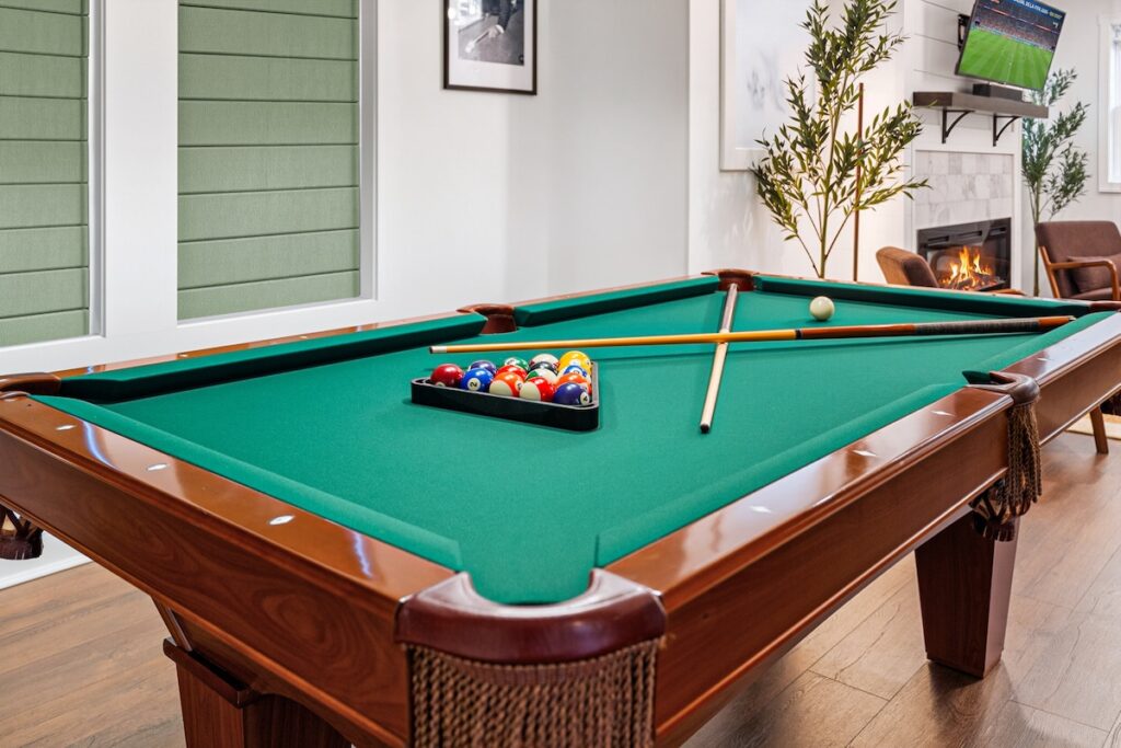 Game Room at Luxury 5BR Oasis in Atlanta, GA – legitimate 7ft Contender billiards table with vintage stained glass pool chandelier