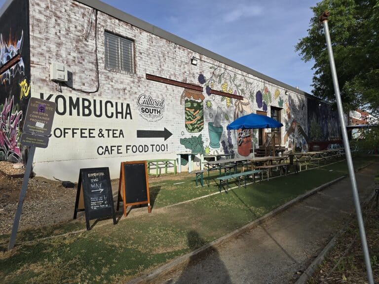 Mural-painted warehouse wall and outdoor picnic seating at Lee + White in Atlanta's West End